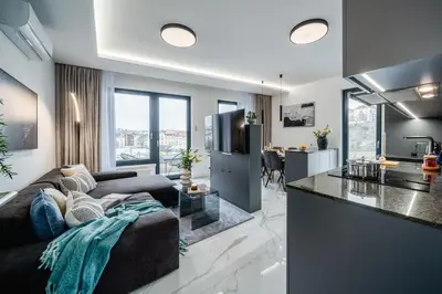 a kitchen and living room with a couch and a counter at Prague Days - Two Bedroom Apartment with Garage, AC, Terrace and Balcony in Vinohrady in Prague