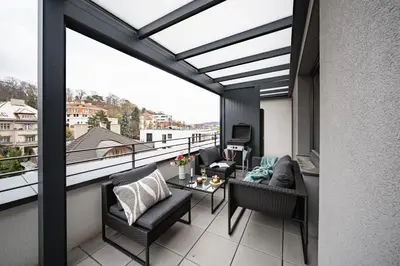 a balcony with a view of a living room at Prague Days - Two Bedroom Apartment with Garage, AC, Terrace and Balcony in Vinohrady in Prague