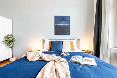 a bedroom with a blue bed with a book on it at Prague Days - Riverside Two-Bedroom Apartment with Workspace in New Town in Prague