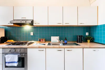 a kitchen with white cabinets and a sink at Prague Days - Riverside Two-Bedroom Apartment with Workspace in New Town in Prague