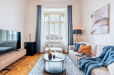 a living room with a couch and a tv at Prague Days - Riverside Two-Bedroom Apartment with Workspace in New Town in Prague