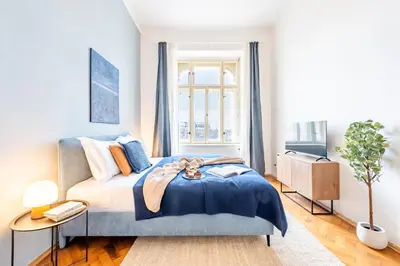 a bedroom with a bed with a blue blanket at Prague Days - Riverside Two-Bedroom Apartment with Workspace in New Town in Prague
