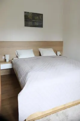 a closet with white cabinets and a wooden bench at Apartmány park in Poděbrady