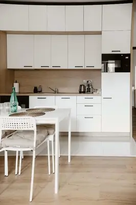 a white kitchen with a white table and chairs at Apartmány park in Poděbrady