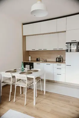 a kitchen with white cabinets and a black microwave at Apartmány park in Poděbrady