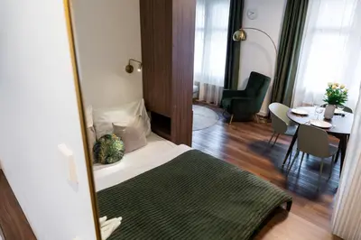 a bedroom with a bed and a table and a mirror at Boutique Apartment by KODA Architekt in Prague