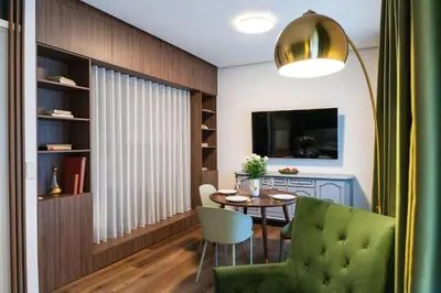 a dining room with a table and a green chair at Boutique Apartment by KODA Architekt in Prague