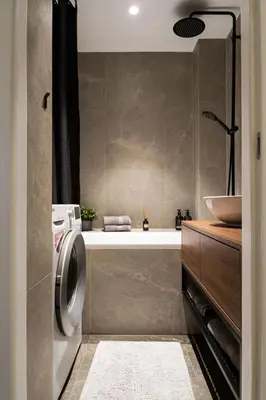 a bathroom with a washing machine and a sink at Boutique Apartment by KODA Architekt in Prague
