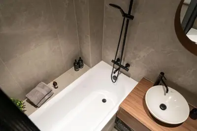 a bathroom with a white tub and a sink at Boutique Apartment by KODA Architekt in Prague