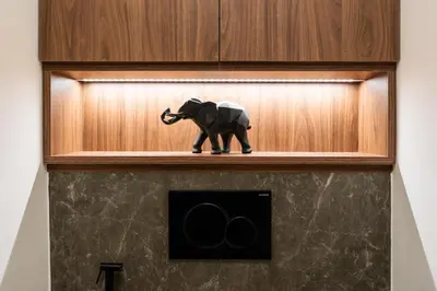 a toy elephant sitting on a shelf in a cabinet at Boutique Apartment by KODA Architekt in Prague
