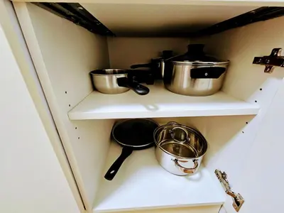 a cabinet with pots and pans on a shelf at SUPERIOR PRAGUE 2BR APARTMENT for Business & Leisure, Private Garden, Free Parking & Gym, by LIVE-INN 1 in Prague