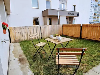 a picnic table and two chairs in a backyard at SUPERIOR PRAGUE 2BR APARTMENT for Business & Leisure, Private Garden, Free Parking & Gym, by LIVE-INN 1 in Prague