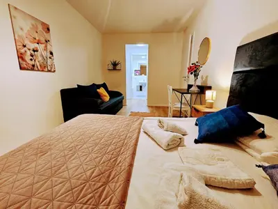a bedroom with a large bed and a living room at SUPERIOR PRAGUE 2BR APARTMENT for Business & Leisure, Private Garden, Free Parking & Gym, by LIVE-INN 1 in Prague