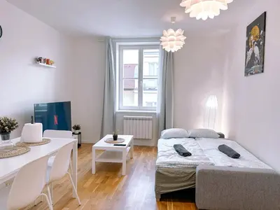 a bedroom with a bed and a dining room at Central Apartment by National Museum&Wenceslas Square in Prague