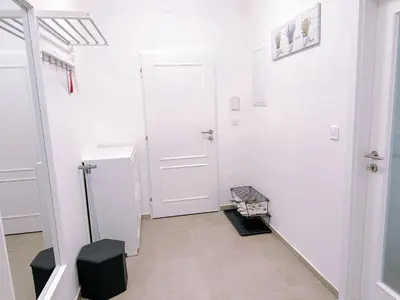 a white hallway with a white door and a black stool at Central Apartment by National Museum&Wenceslas Square in Prague
