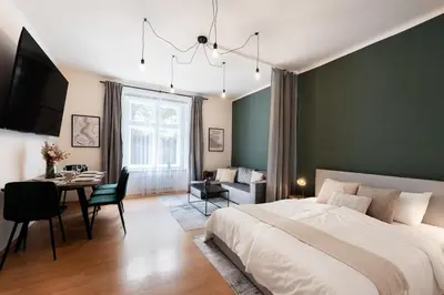 a bedroom with a large bed and a dining room at Klidný byt v centru se saunou in Prague