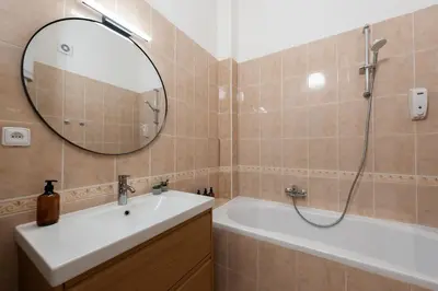 a bathroom with a tub and a sink and a mirror at Klidný byt v centru se saunou in Prague