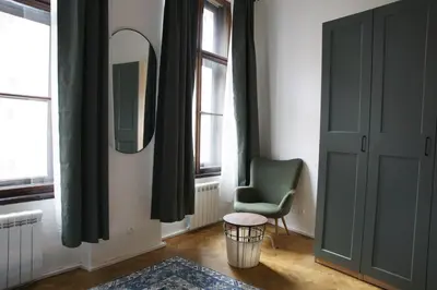a room with a green chair and a mirror at Prague Properties Rental in Prague