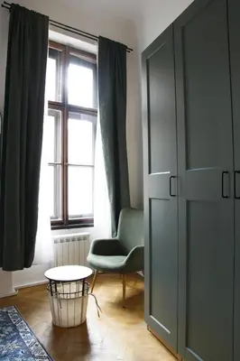 a room with a chair and a table and a window at Prague Properties Rental in Prague