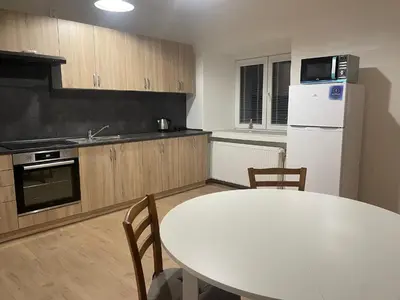 a kitchen with a white table and a white refrigerator at Byt v okolí letiště a Prahy in Velké Číčovice