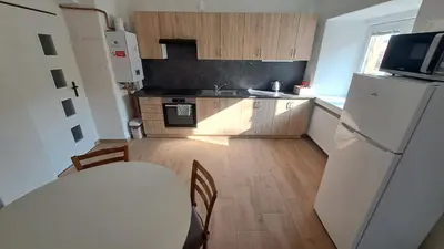 a kitchen with a white table and a white refrigerator at Byt v okolí letiště a Prahy in Velké Číčovice