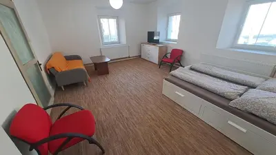 a living room with a tv and chairs and a table at Byt v okolí letiště a Prahy in Velké Číčovice
