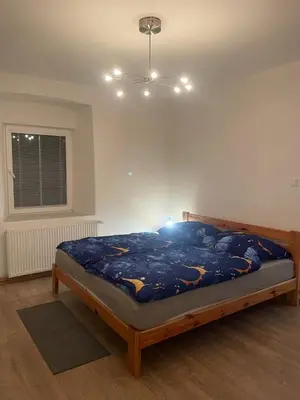 a bedroom with a bed and a red chair at Byt v okolí letiště a Prahy in Velké Číčovice