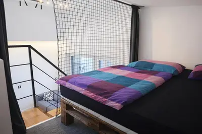 a bed with a striped comforter in a room at Ubytování Městská hora Beroun - Sauna in Beroun