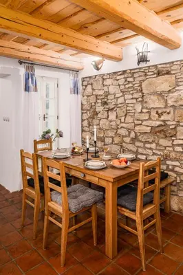a wooden table with chairs and a stone wall at Prague Days - Cozy House near Prague Castle with Desk and Balcony in Prague