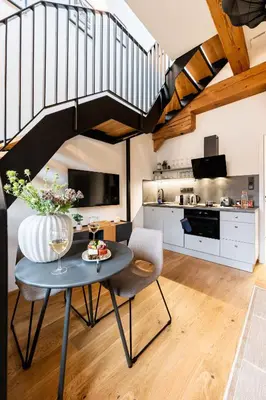 a living room with a table and a staircase at Prague Days - One Bedroom Apartment with Garage and Workspace in Prague