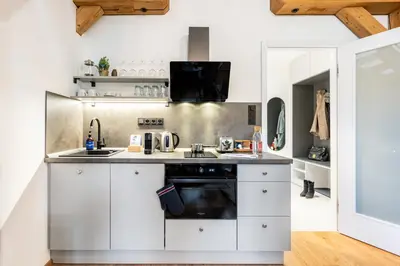 a kitchen with white cabinets and a dishwasher at Prague Days - One Bedroom Apartment with Garage and Workspace in Prague