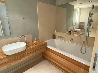 a bathroom with a sink and a tub and a mirror at River Diamond Central Residence in Prague