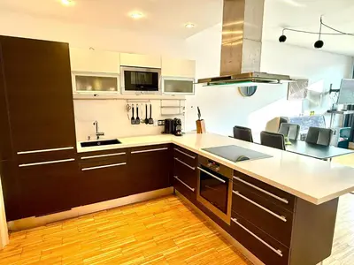a kitchen with brown cabinets and white counter tops at River Diamond Central Residence in Prague