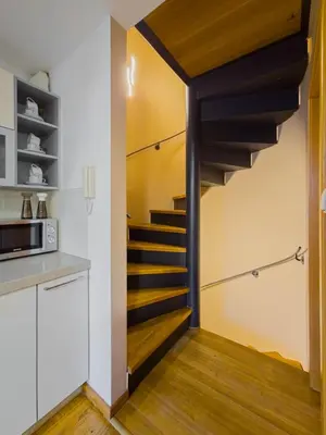 a spiral staircase in a kitchen with white walls and wooden floors at Triplex Apartment with Private Terrace in Prague