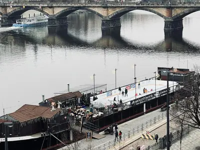 a boat is docked at a dock on a river at Quiet Apartment Farmers' Saturday Market in Prague