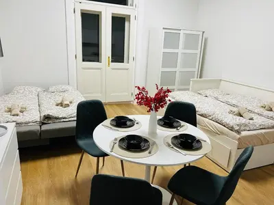 a living room with a table and chairs and a bed at Quiet Apartment Farmers' Saturday Market in Prague