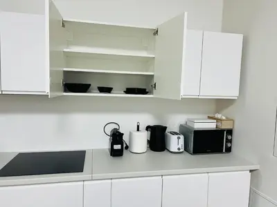 a kitchen with white cabinets and a microwave at Quiet Apartment Farmers' Saturday Market in Prague