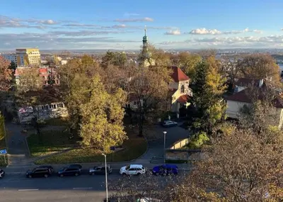 a view of a city with cars parked in a parking lot at Panoramic top floor flat across the metro in Prague