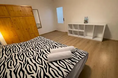a room with a zebra print bed with towels on it at Panoramic top floor flat across the metro in Prague