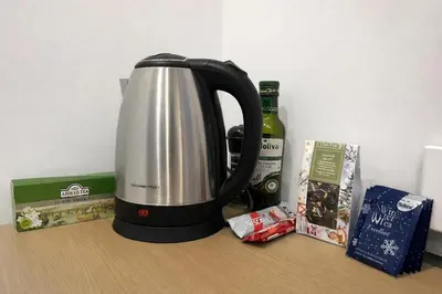 a tea kettle sitting on a counter next to a bottle of wine at Panoramic top floor flat across the metro in Prague