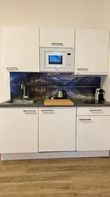 a white cabinet with plates and cups and dishes at Prague 1 - Central Cozy Apartment in Prague