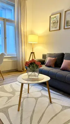 a living room with a blue couch and a table at Prague 1 - Central Cozy Apartment in Prague