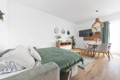 a white bedroom with a bed and a dining room at Kajetanka Residence - with free weekend parking in Prague