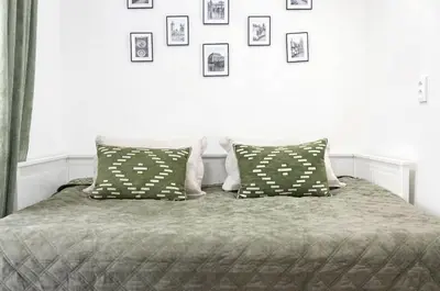 a bedroom with a bed with pillows and pictures on the wall at Kajetanka Residence - with free weekend parking in Prague