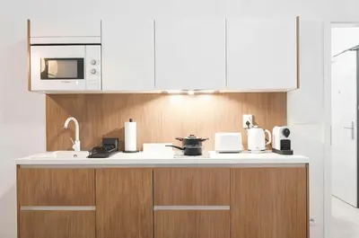 a kitchen with white cabinets and a counter top at Kajetanka Residence - with free weekend parking in Prague