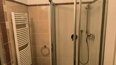 a shower with a glass door in a bathroom at Balbín Central Apartment in Prague