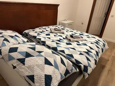 a bed with a blue and white quilt on it at Balbín Central Apartment in Prague