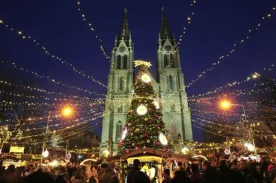 a christmas market with a christmas tree in front of two towers at Balbín Central Apartment in Prague
