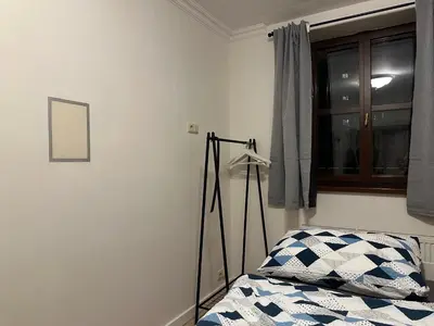 a bedroom with a bed and a tripod next to a window at Balbín Central Apartment in Prague