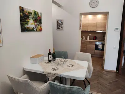 a dining room with a table with wine bottles and chairs at Get Prague Flat Trojanova in Prague